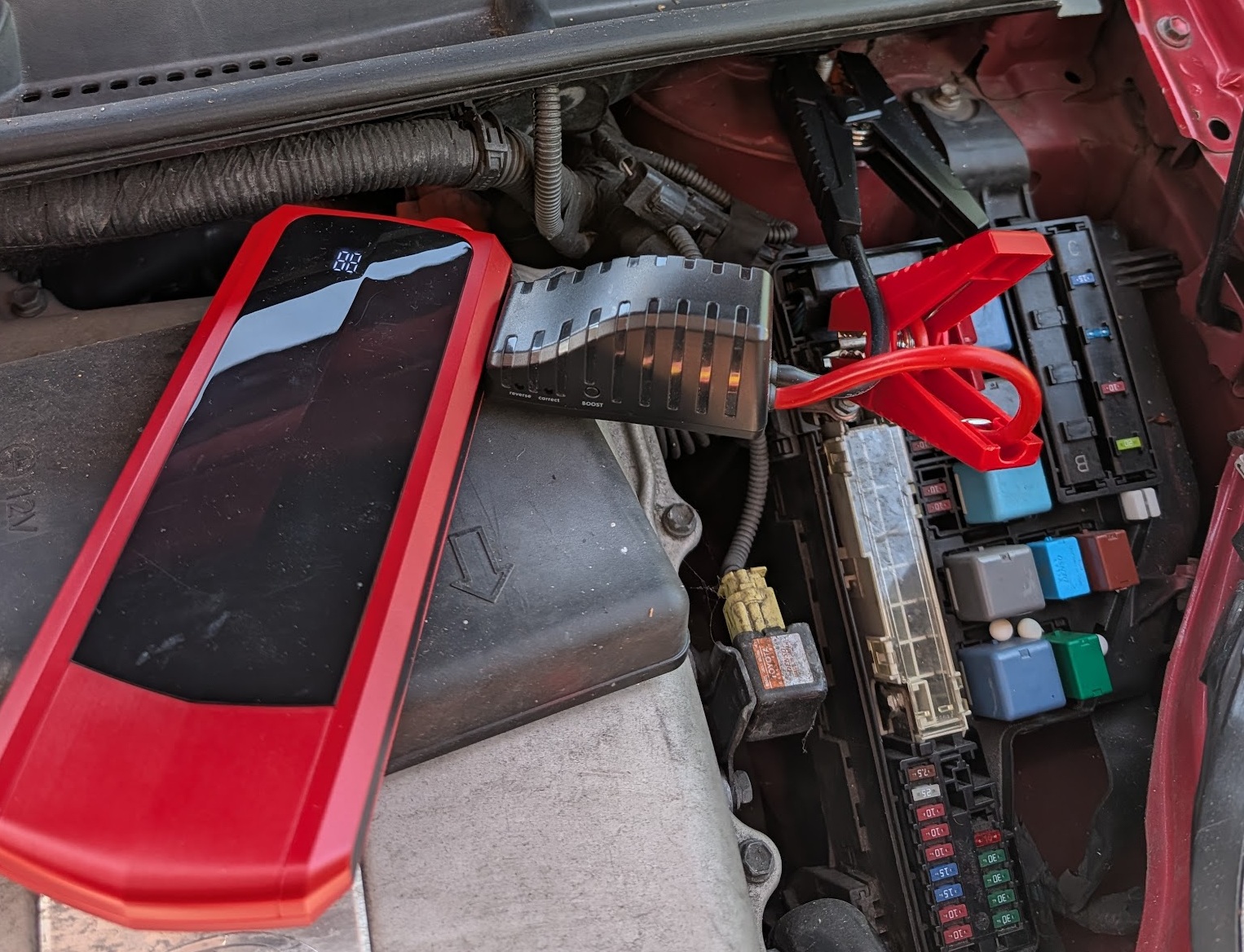 Portable jump starter connected to the front fuse box positive terminal