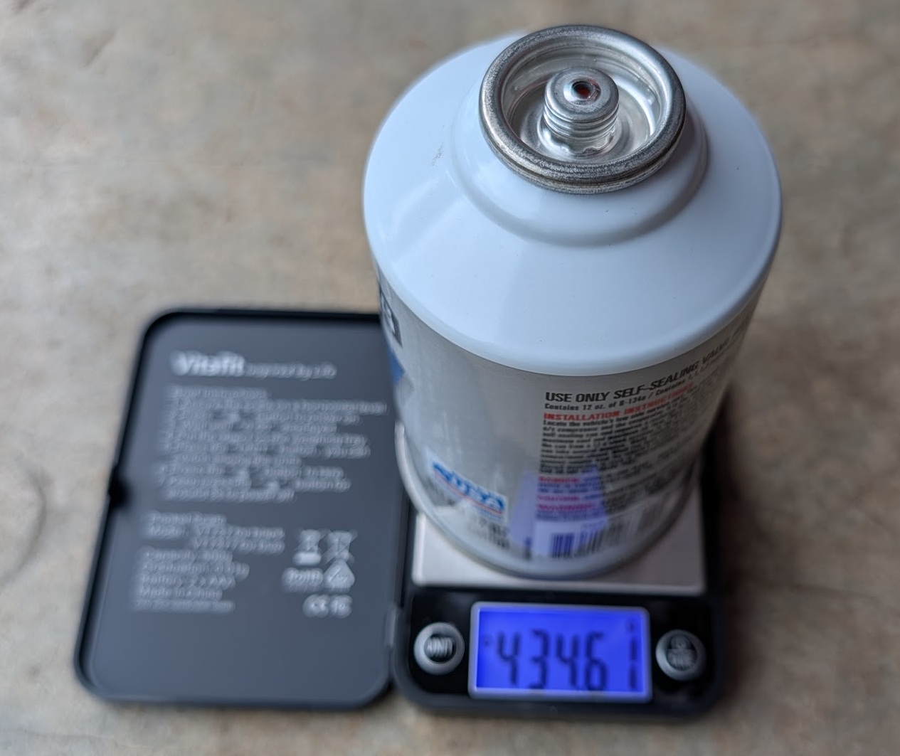 Kitchen scale showing R-134a can at 434g before recharging - weigh before and after to track how much refrigerant was added